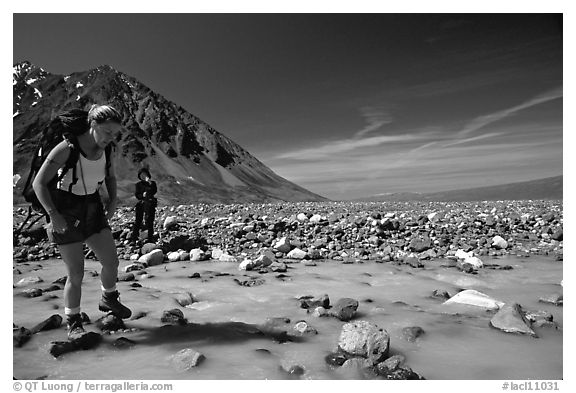 Hiker crossing a stream next to Lake Turquoise. Lake Clark National Park, Alaska