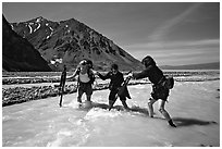 Hikers crossing a stream next to Lake Turquoise. Lake Clark National Park, Alaska (black and white)