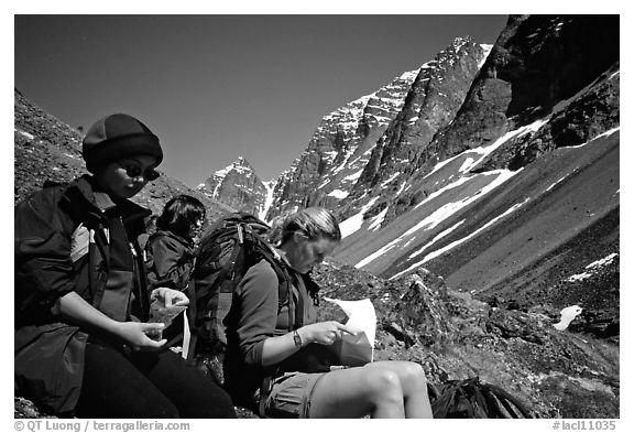 Women hikers pausing below the Telaquana Mountains. Lake Clark National Park, Alaska