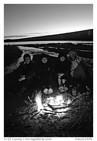 Campers warming toes in campfire next to Turquoise Lake. Lake Clark National Park, Alaska