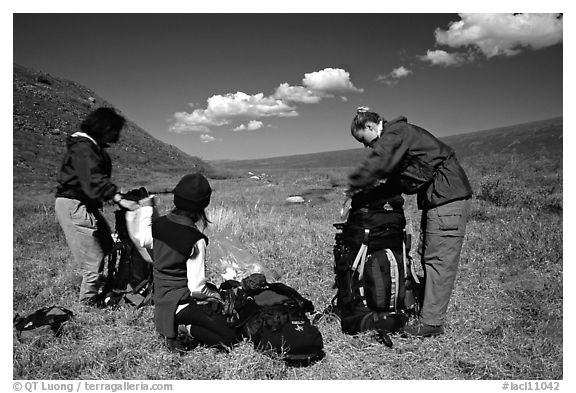 Backpackers breaking camp and readying backpacks. Lake Clark National Park, Alaska