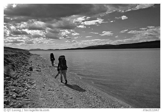 Backpackers walking on the shore of Turquoise Lake. Lake Clark National Park, Alaska
