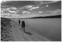 Backpackers walking on the shore of Turquoise Lake. Lake Clark National Park, Alaska (black and white)