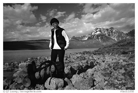 Backpacker pausing on the shore of Turquoise Lake. Lake Clark National Park, Alaska