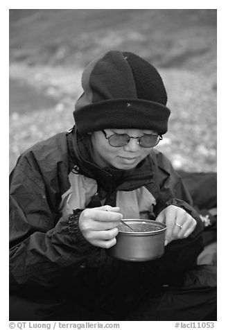 Backpacker eating camp food. Lake Clark National Park, Alaska