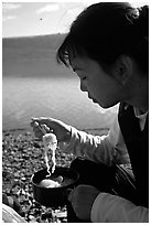 Backpacker eating noodles from a camp pot. Lake Clark National Park, Alaska (black and white)