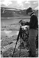 Large format photographer with camera on the shores of Turquoise Lake. Lake Clark National Park, Alaska (black and white)