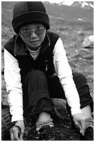 Woman backpacker putting back boots after a stream crossing. Lake Clark National Park, Alaska (black and white)