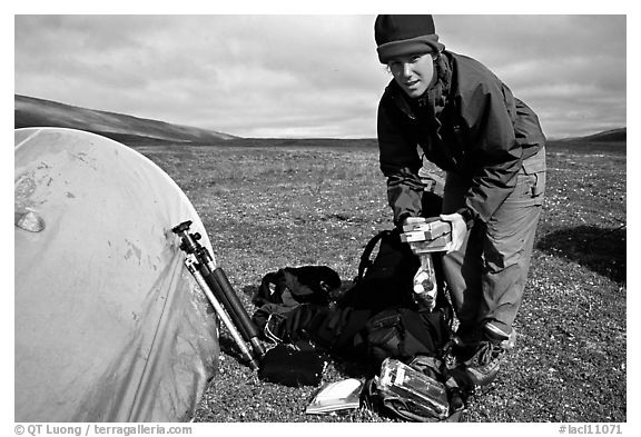 Photographer unpacking boxes of film from backpack. Lake Clark National Park, Alaska