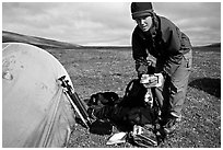 Photographer unpacking boxes of film from backpack. Lake Clark National Park, Alaska (black and white)