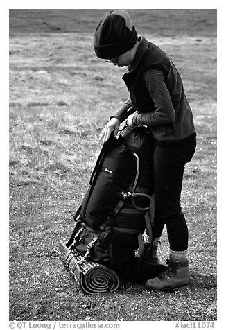 Backpacker finishes packing up backpack. Lake Clark National Park, Alaska