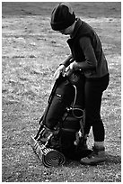 Backpacker finishes packing up backpack. Lake Clark National Park, Alaska (black and white)