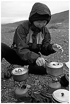 Backpacker cooks meal on gas campstove. Lake Clark National Park, Alaska (black and white)