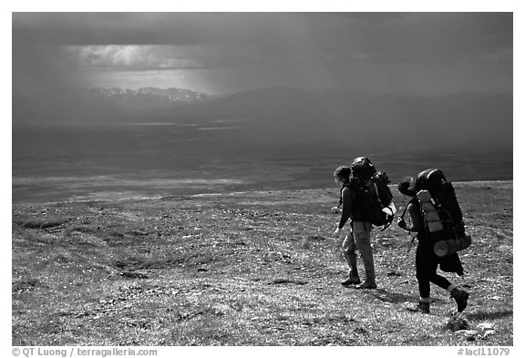 Two backpackers arrive at a ridge as a storm clears. Lake Clark National Park, Alaska