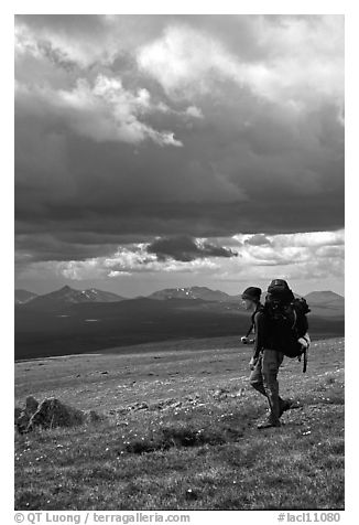 Backpacker seen from the side walking fast in the tundra. Lake Clark National Park, Alaska