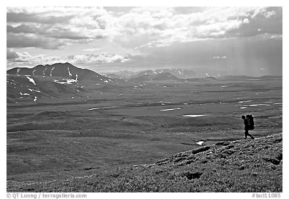 Backpacker on a ridge above vast expenses of tundra. Lake Clark National Park, Alaska