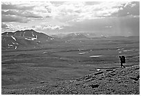 Backpacker on a ridge above vast expenses of tundra. Lake Clark National Park, Alaska (black and white)