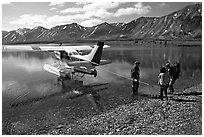Backpackers being picked up by floatplane at Twin Lakes. Lake Clark National Park, Alaska (black and white)