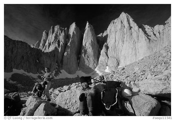 Man and woman pausing with backpacks below the East face of Mt Whitney. Sequoia National Park, California