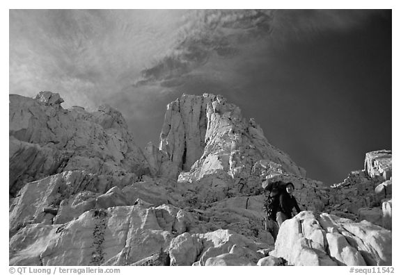 Looking up to woman scrambling on rocks on the East face of Mt Whitney. Sequoia National Park, California