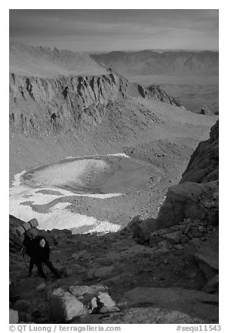 Woman on steep slope above frozen Iceberg Lake. Sequoia National Park, California