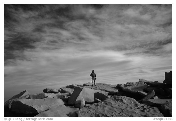 Hiker standing on flat rocks on top of Mt Whitney summit. Sequoia National Park, California