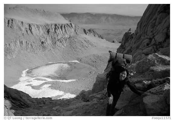 Woman with backpack pausing on steep terrain above Iceberg Lake. Sequoia National Park, California