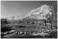 Hikers crossing stream on rocks at Long Lake, John Muir Wilderness. Kings Canyon National Park, California (black and white)