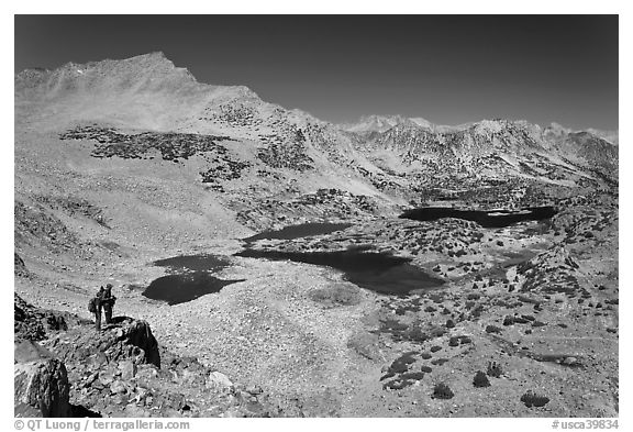 Hikers looking at view  above Saddlebag Lakes, John Muir Wilderness. Kings Canyon National Park, California