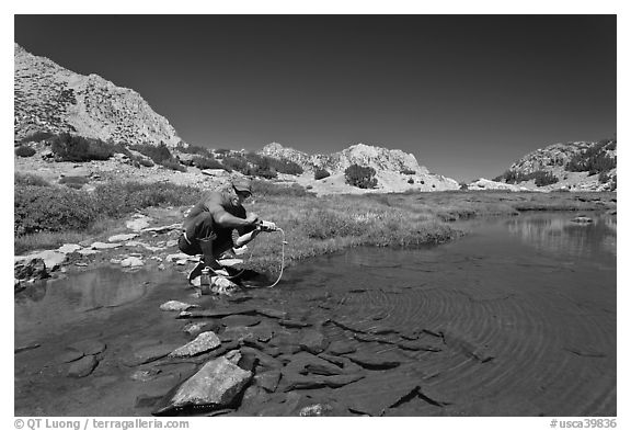 Man filtering water from stream, John Muir Wilderness. Kings Canyon National Park, California