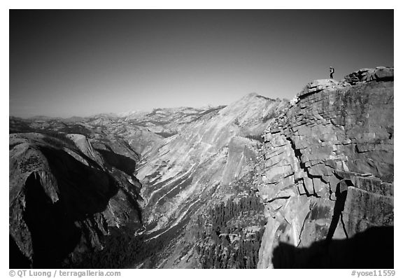 Hiker standing on top of Half-Dome, overlooking Tenaya Canyon. Yosemite National Park, California