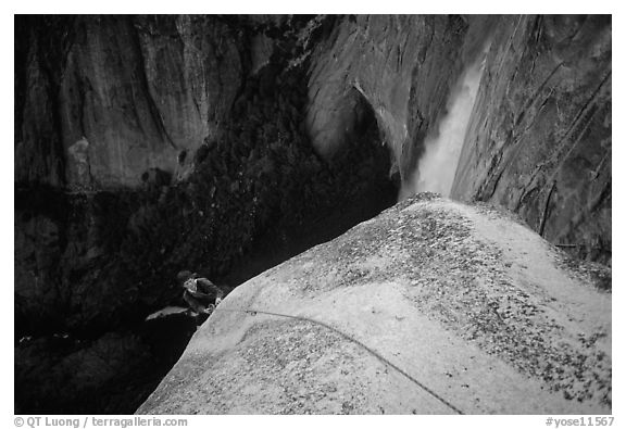 Climber near the top of Lost Arrow spire with Yosemite Falls behind. Yosemite National Park, California