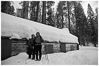 Skiing couple in front of the Mariposa Grove Museum in winter. Yosemite National Park, California (black and white)
