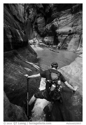 Hiker straddling stream in Orderville Canyon. Zion National Park (black and white)