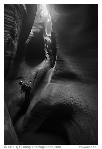 Canyoneer rappels deeps inside Keyhole Canyon. Zion National Park (black and white)
