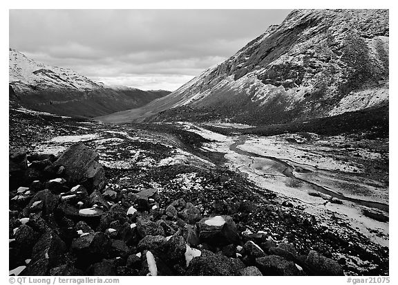 Boulders, valleys and slopes with fresh snow in cloudy weather. Gates of the Arctic National Park, Alaska, USA.