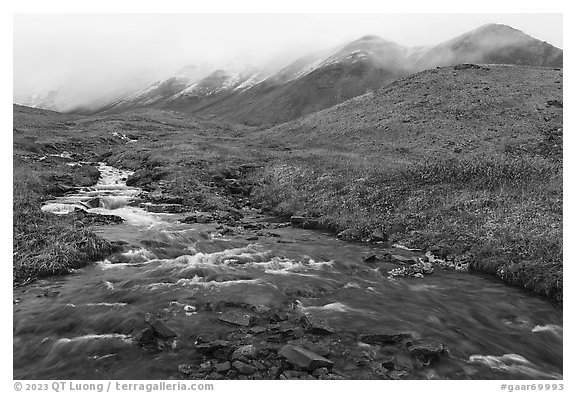 Creek flowing below peaks with fresh snow. Gates of the Arctic National Park (black and white)