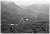 Visitor looking, Inukpasugruk Creek drainage in the rain. Gates of the Arctic National Park ( black and white)