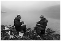 Backpackers eating on shore of foggy lake. Gates of the Arctic National Park ( black and white)