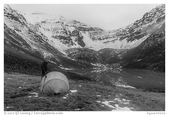 Camper standing by tent near  Lake and Three River Mountain. Gates of the Arctic National Park (black and white)