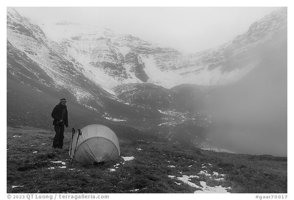 Camper standing by tent with fog approaching. Gates of the Arctic National Park (black and white)