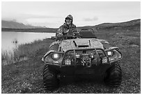 Nunamiut man driving all-terrain vehicle. Gates of the Arctic National Park ( black and white)