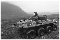 Nunamiut man driving eight-wheeled all-terrain vehicle. Gates of the Arctic National Park ( black and white)