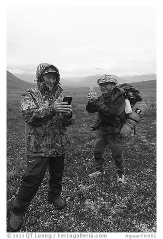 Nunamiut man and visiting backpacker with cell phones. Gates of the Arctic National Park (black and white)