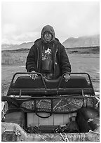 Nuamiunt boy standing on all-terrain vehicle, Anaktuvuk Pass Airport. Gates of the Arctic National Park ( black and white)