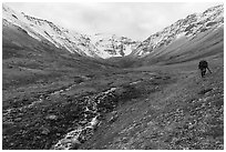 Hiker above stream, Three River Mountain. Gates of the Arctic National Park ( black and white)