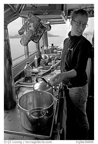 Chef cooking aboard small boat. Glacier Bay National Park, Alaska, USA.