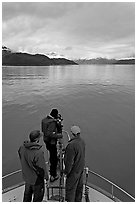 Film crew working on the bow of a small boat. Glacier Bay National Park ( black and white)