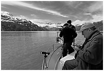 Film producer taking notes as crew films. Glacier Bay National Park, Alaska, USA. (black and white)