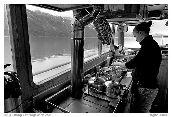 Chef preparing sadad in the main cabin of the Kahsteen. Glacier Bay National Park, Alaska, USA.